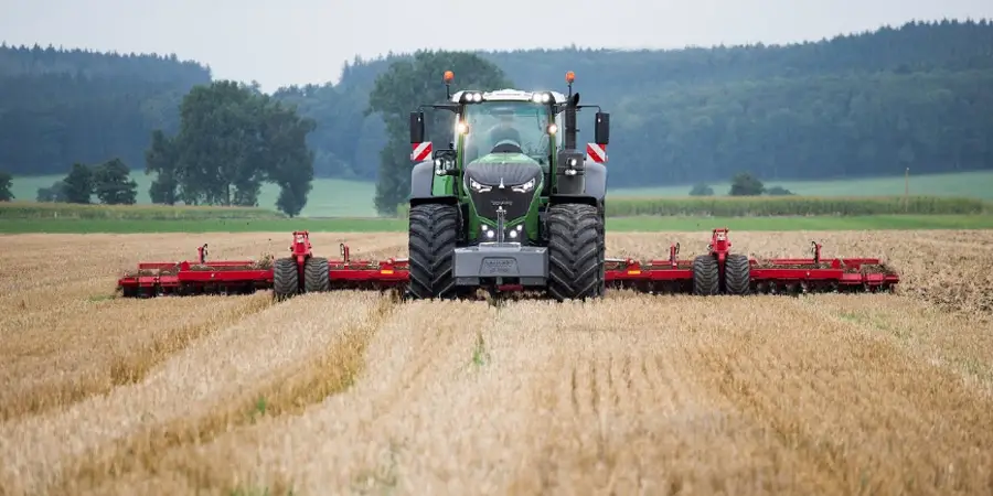 This picture shows a deep tillage machine in operation, working the soil in a farm field, showcasing the vital role of agricultural machinery in preparing the land for planting by breaking up compacted soil layers.